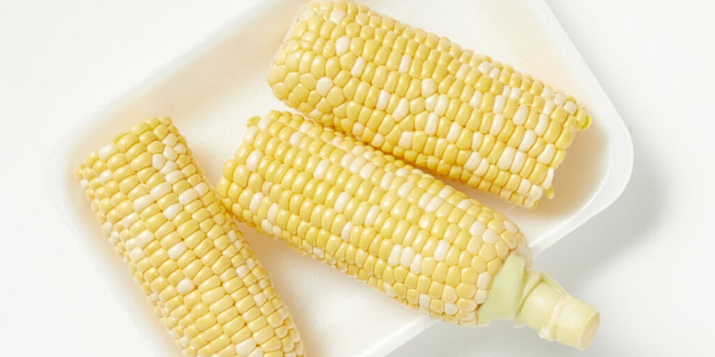 Corn, grocery store produce, on a blank background.