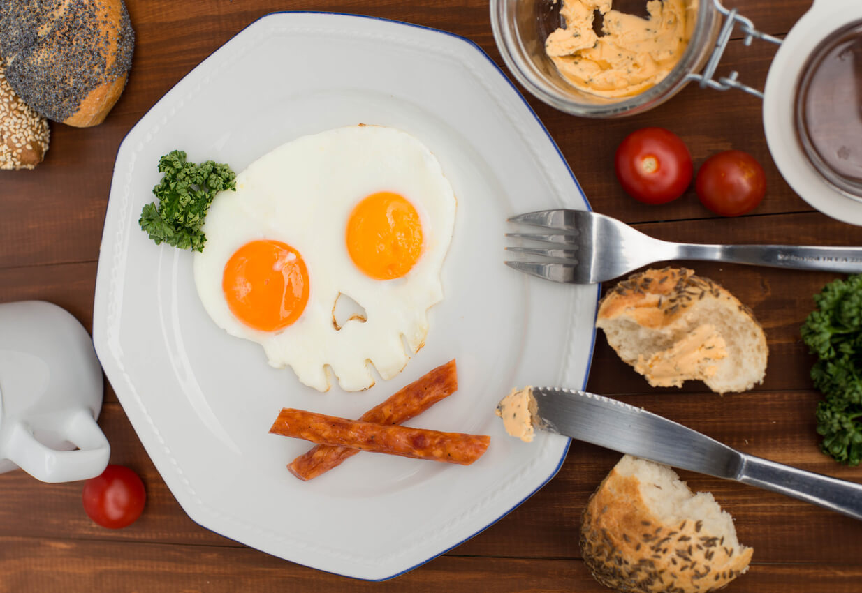 Fried eggs in the form of a skull on wooden table. 