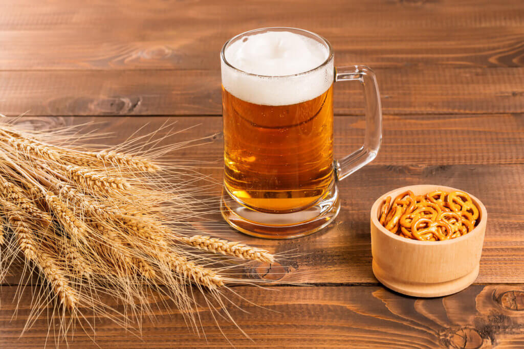 Oktoberfest Beer Mug and traditional German pretzels with wheat cones on the wood table