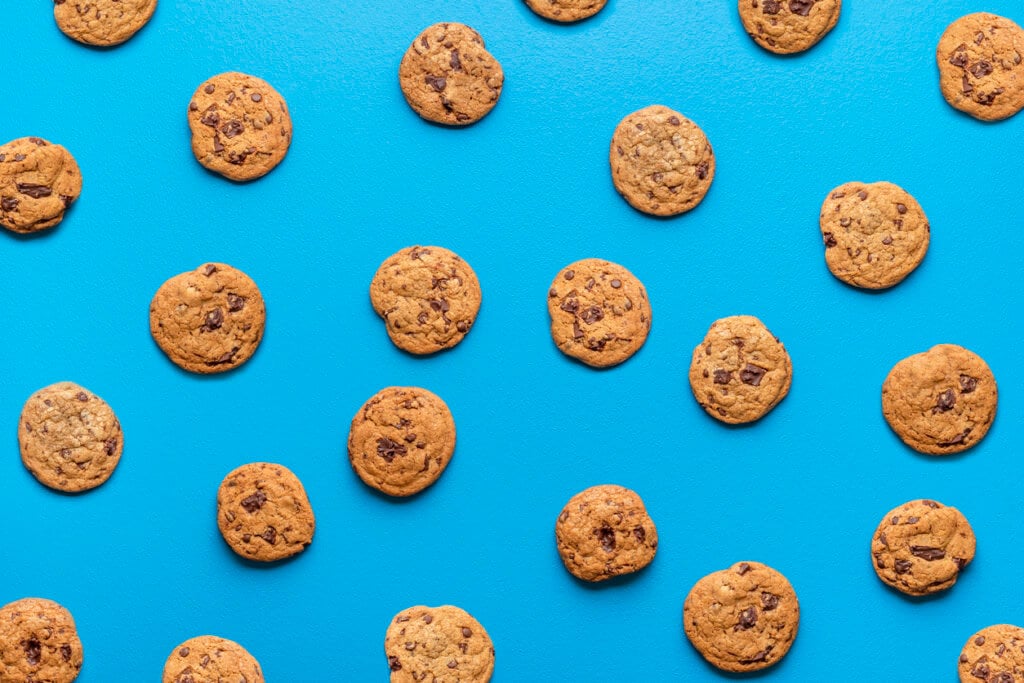 Chocolate chip cookies background. Cookies pattern on blue color