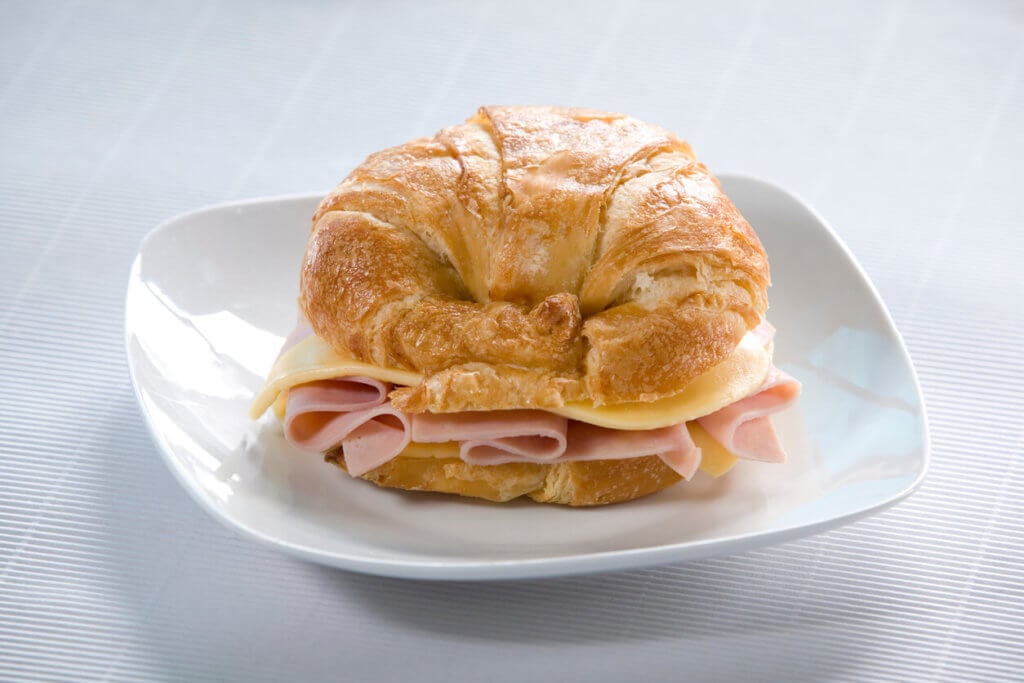 Close-up of croissant sandwich on white plate