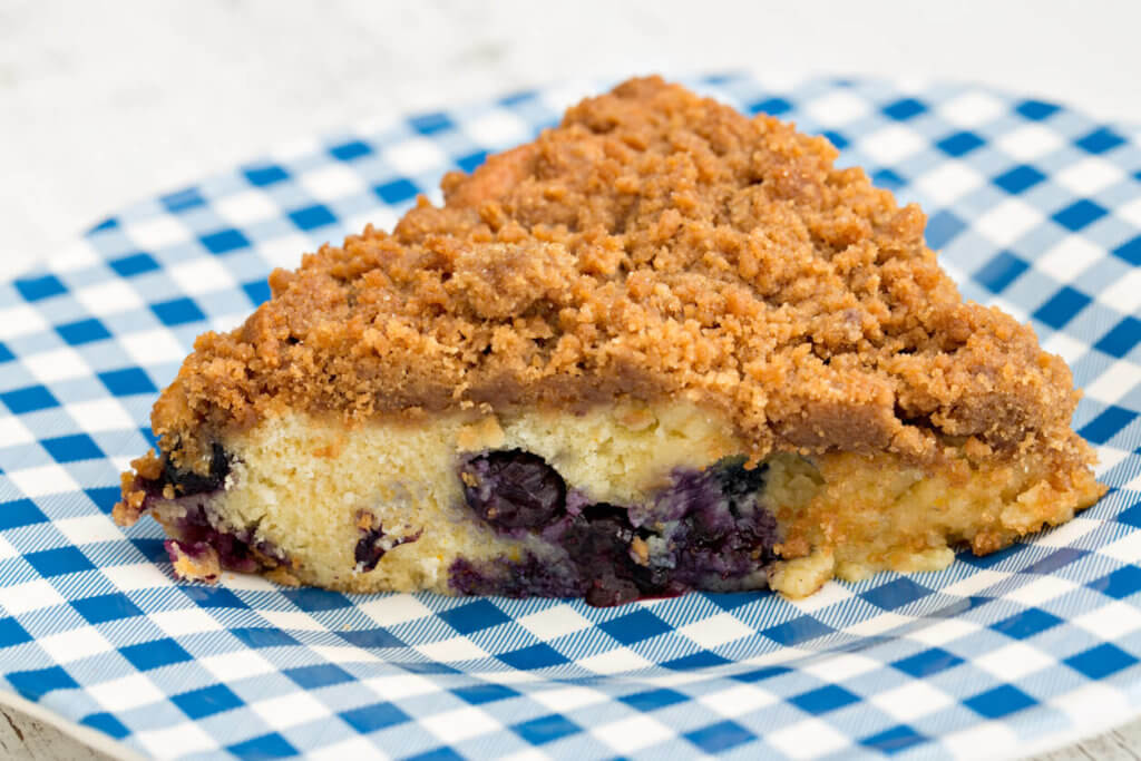 A high angle close up shot of a slice of freshly baked blueberry buckle.