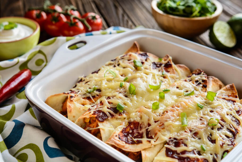 Traditional mexican enchiladas with chicken meat, spicy tomato sauce, corn, beans and cheese.