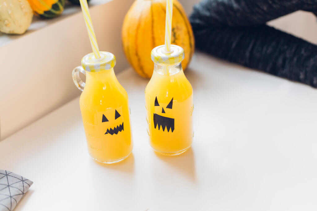 Two Halloween decorated bottles of drink. 