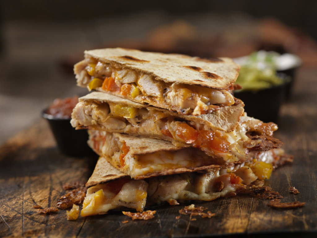Cheesy Chicken Quesadilla sliced on a table.