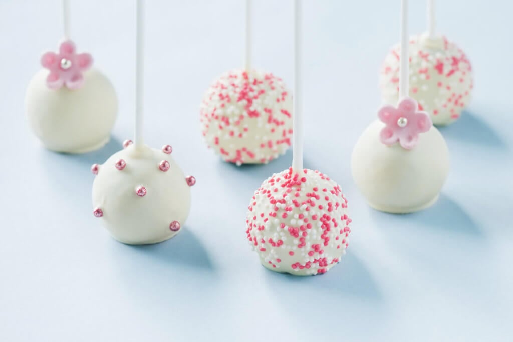 Tasty white wedding cake pops decorated with sprinkles.