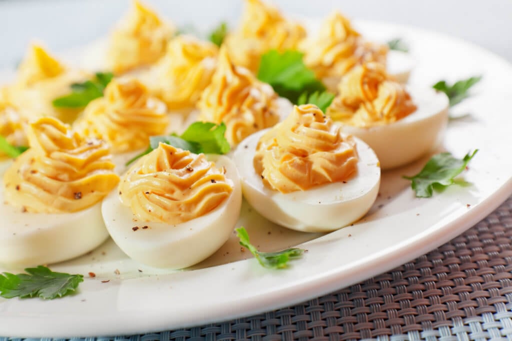 Stuffed eggs with mustard and yolk in a plate.