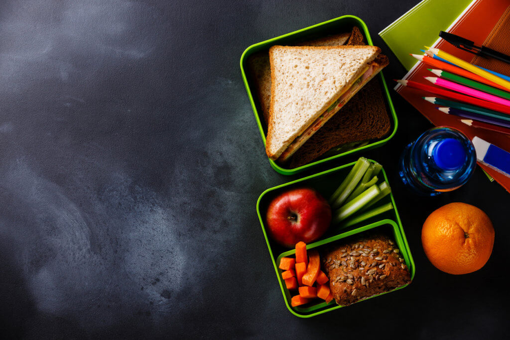 Lunch box with Sandwiches, bottle of water and school supplies