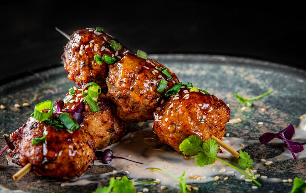 deep fried meatballs in plate on black wooden table background.