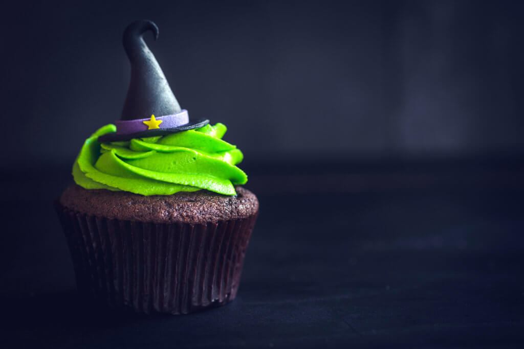 Witch hat cupcake on dark background with blank space.