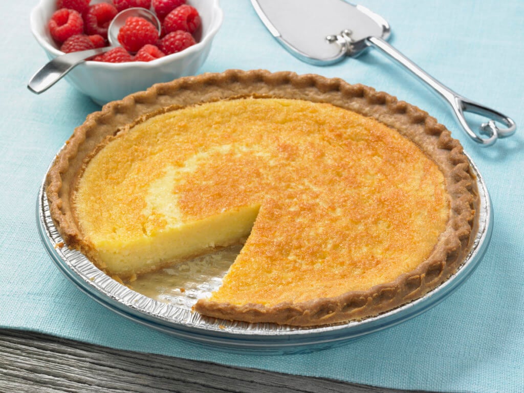 A delicious, homemade American Southern style grits' pie, ready to serve with fresh raspberries. 