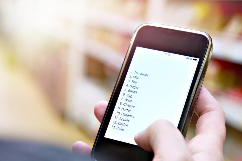 Shopping list on smartphone screen in the hand of customer.