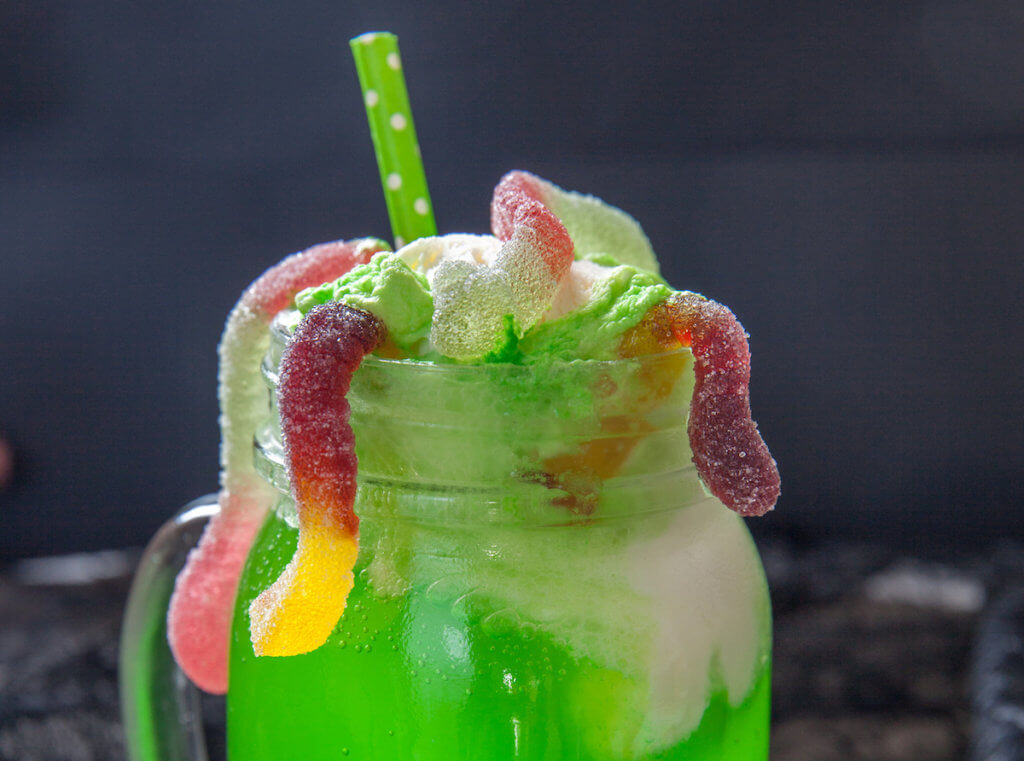 Green drink with ice cream float and gummy worms for Halloween