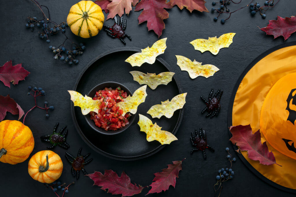 Halloween table setting with red salsa and bat tortilla chips, kids party simple snack recipe idea.