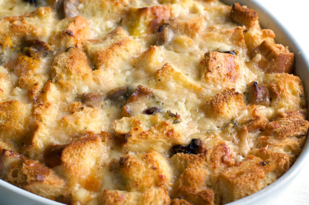 Closeup of golden melted cheese and savory bread pudding.