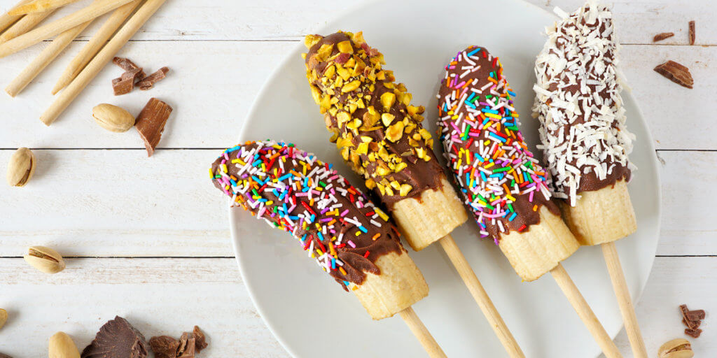 Frozen chocolate dipped bananas on a plate.