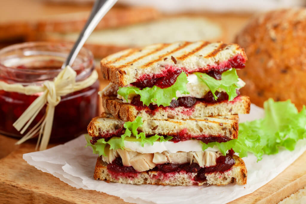 Delicious Turkey or chicken sandwich with brie or Camembert cheese, lettuce and cranberry.