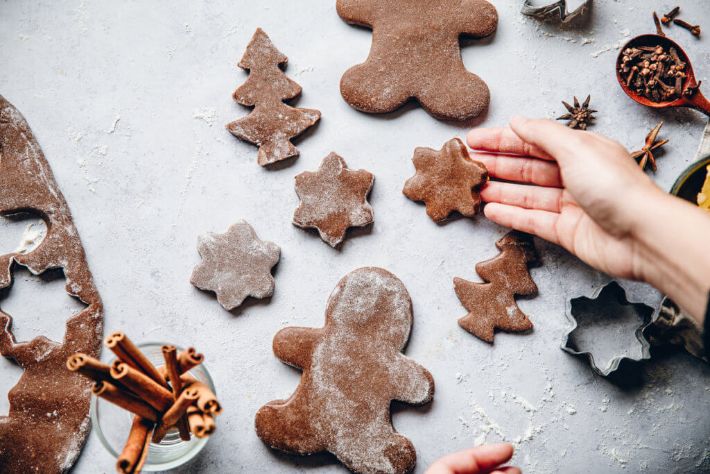 Woman preparing Christmas gingerbread cookies in kitchen. 
