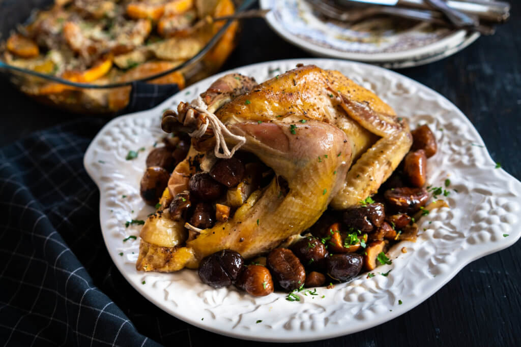 Autumn-style cooked pheasant with oranges, pumpkin, olives and greens