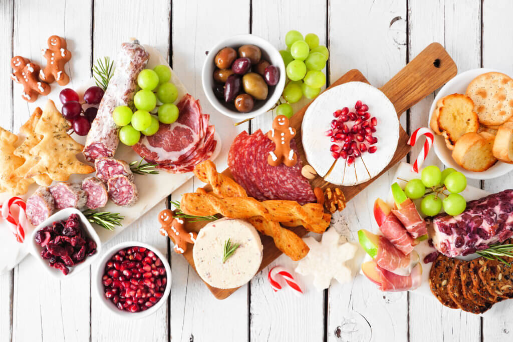 Holiday charcuterie table scene, top view against a white wood background