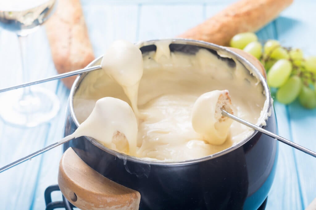 Cheese fondue with bread wine and grape .