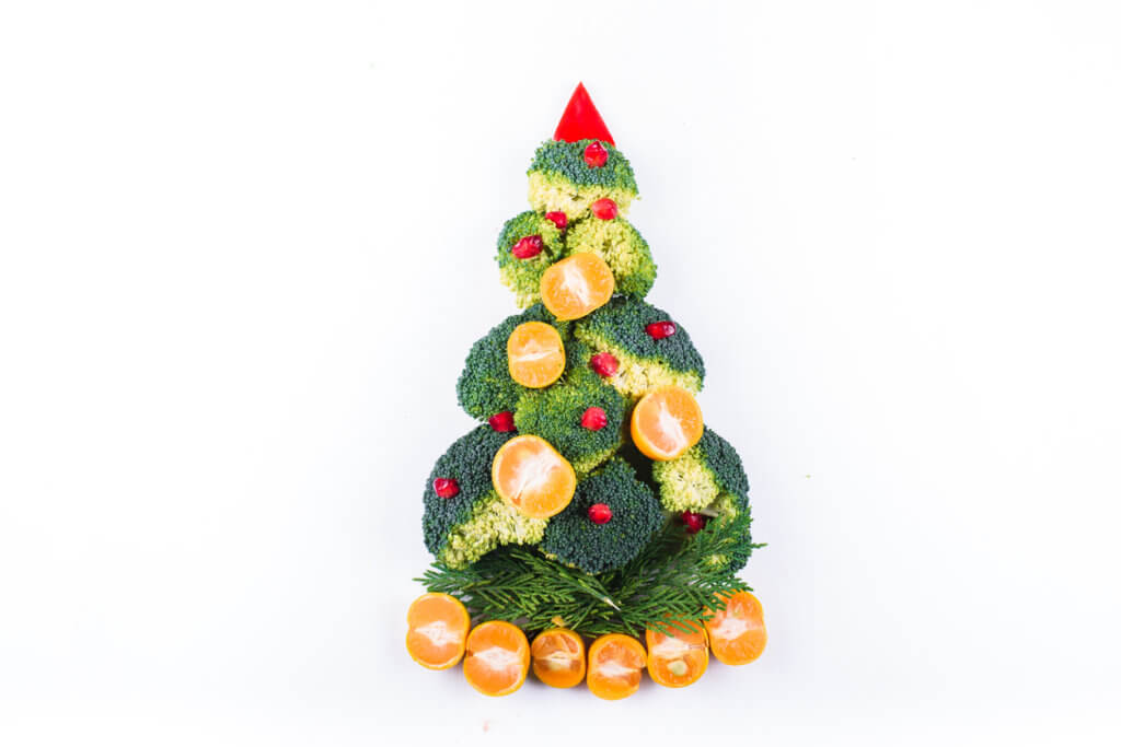 Christmas tree made of broccoli, mandarins and pomegranate seeds. 