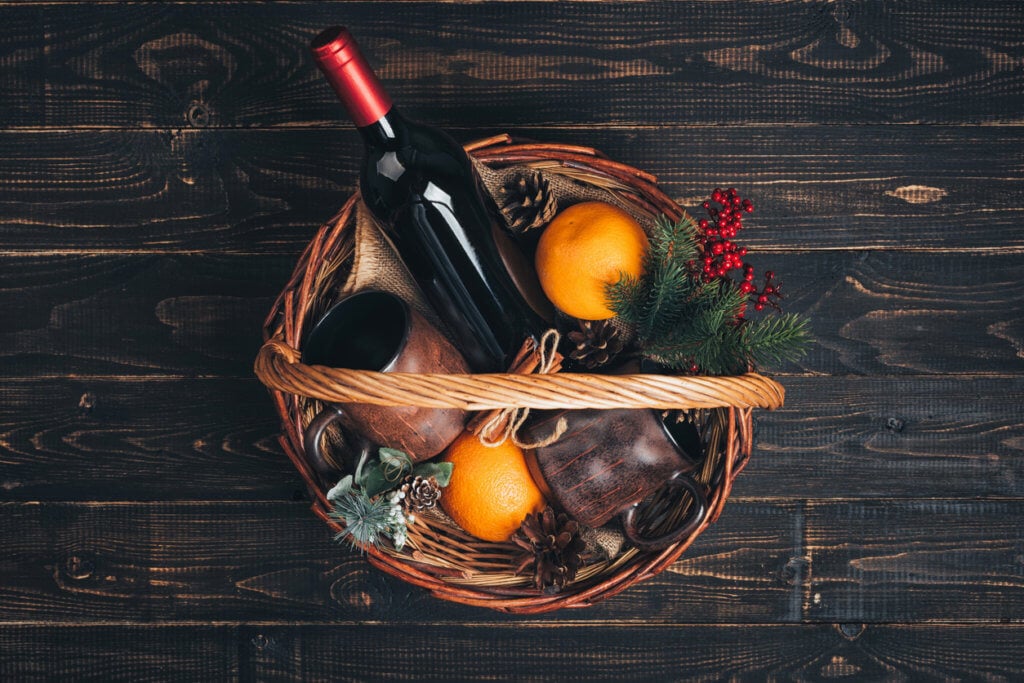 Bottle of red wine in Christmas gift basket.