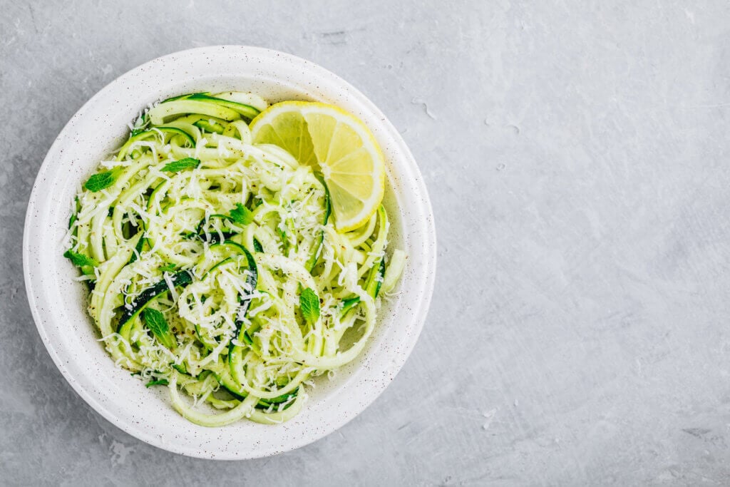 Green vegetarian pasta. Spiralized zucchini noodles with mint, lemon and parmesan cheese,.
