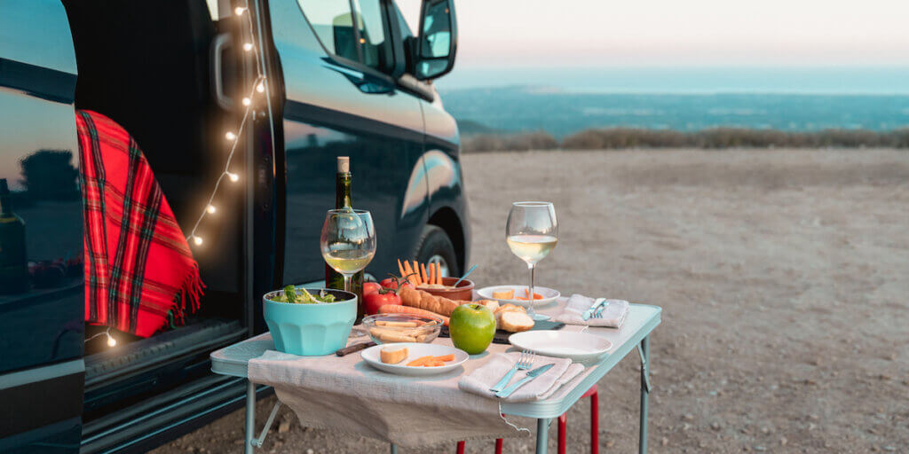 picnic celebration in camper van with landscape in background