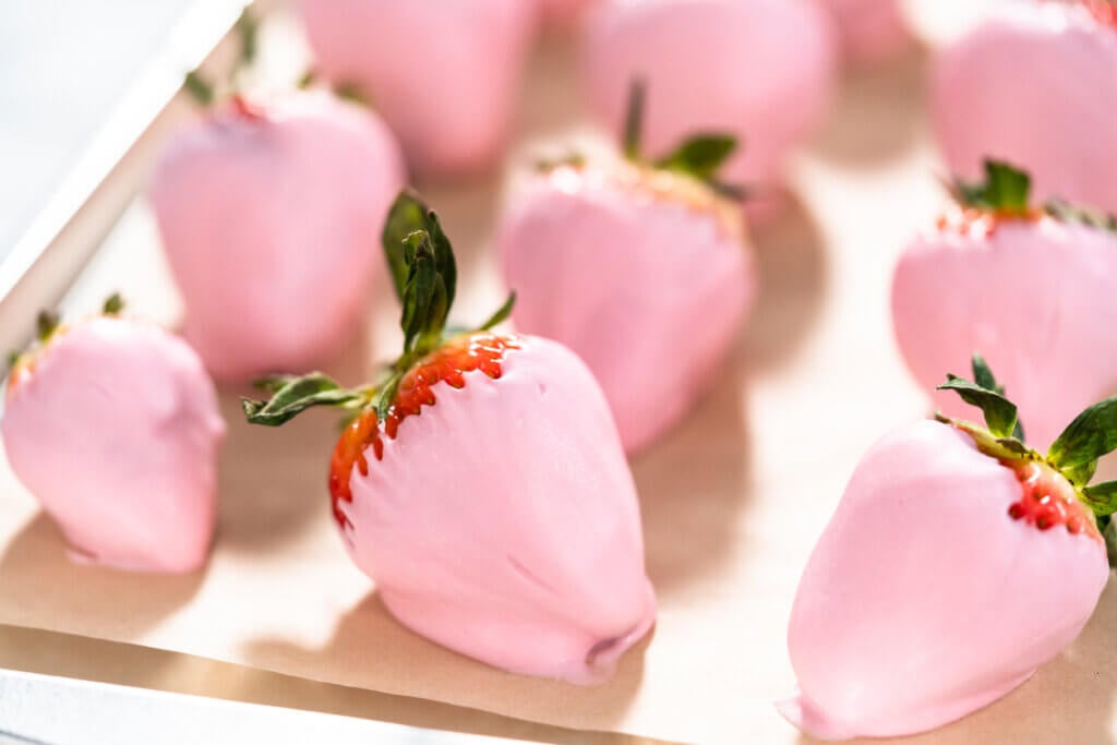 Close up of chocolate dipped strawberries on a parchment paper.