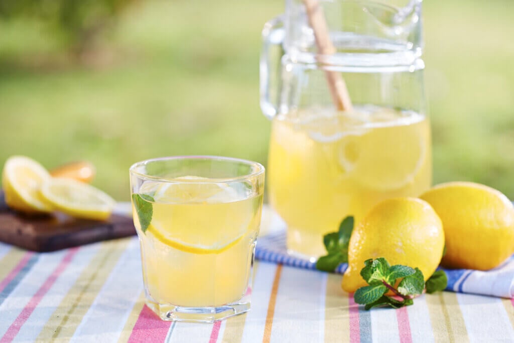 Glass of homemade lemonade in a garden table