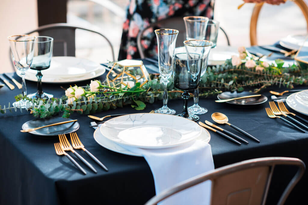 Black and gold color Elegant table set for Wedding celebration reception in barn or luxury dinner party