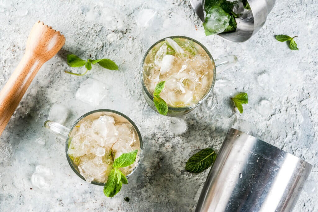 Cold summer beverage, mint julep cocktail drink, grey stone background copy space