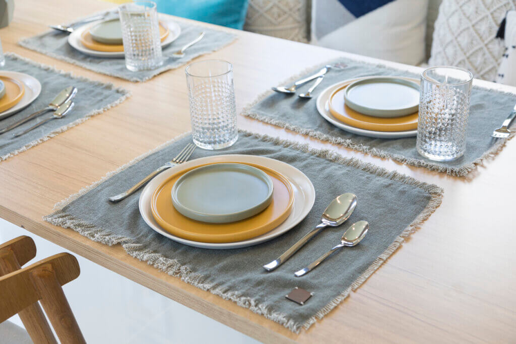 Table setting with yellow plate in modern style dining room at home.