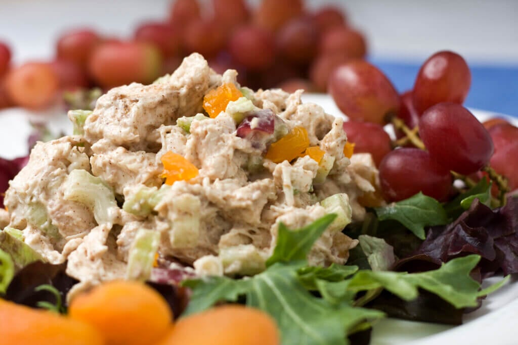 Curried spiced chicken salad with dried apricots and grapes, served on a bed of lettuce.