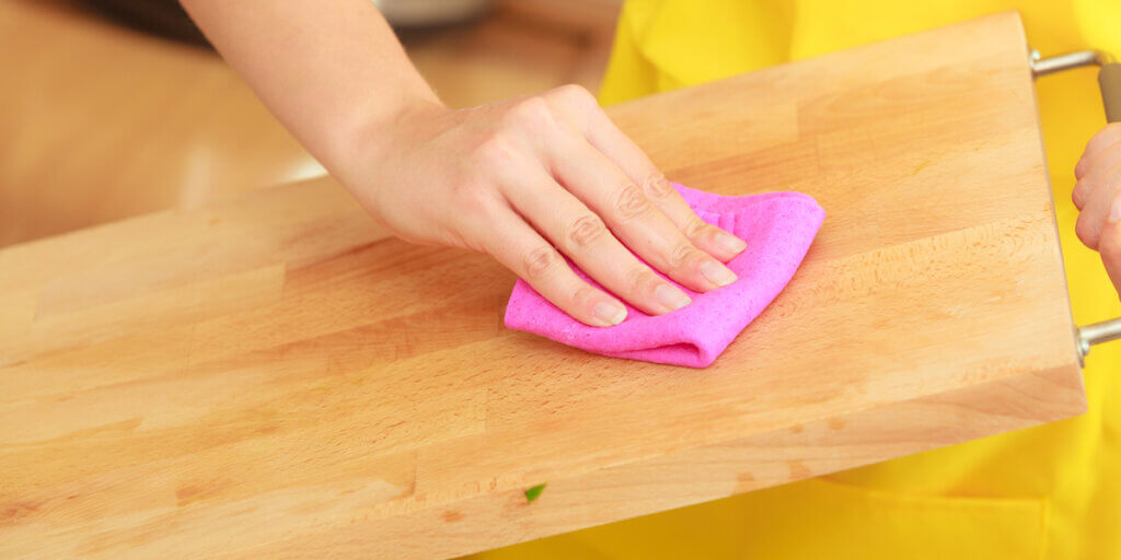 Cleaning a cutting board with a wipe..