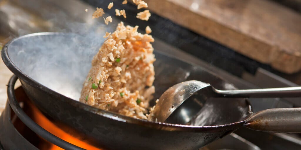Closeup of fried rice being cooked in wok