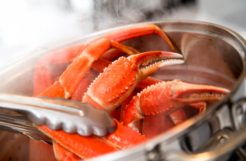 Cooking crab legs in a boiling pot.