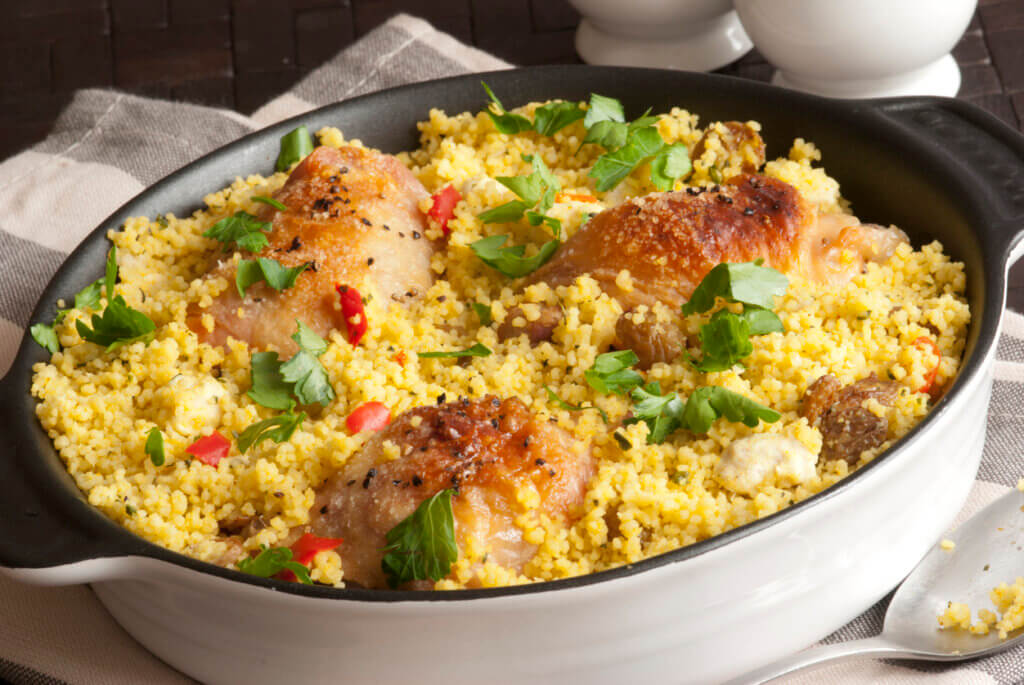 Grilled chicken thighs with Moroccan couscous and herbs in a pot
