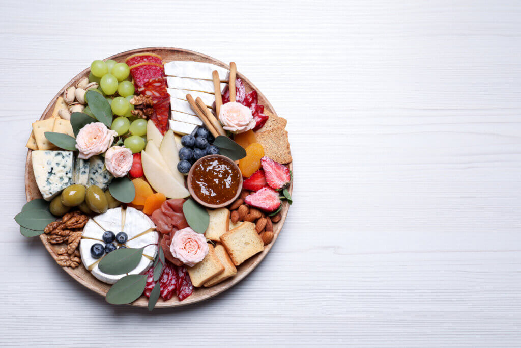 Assorted appetizer served on white wooden table, top view