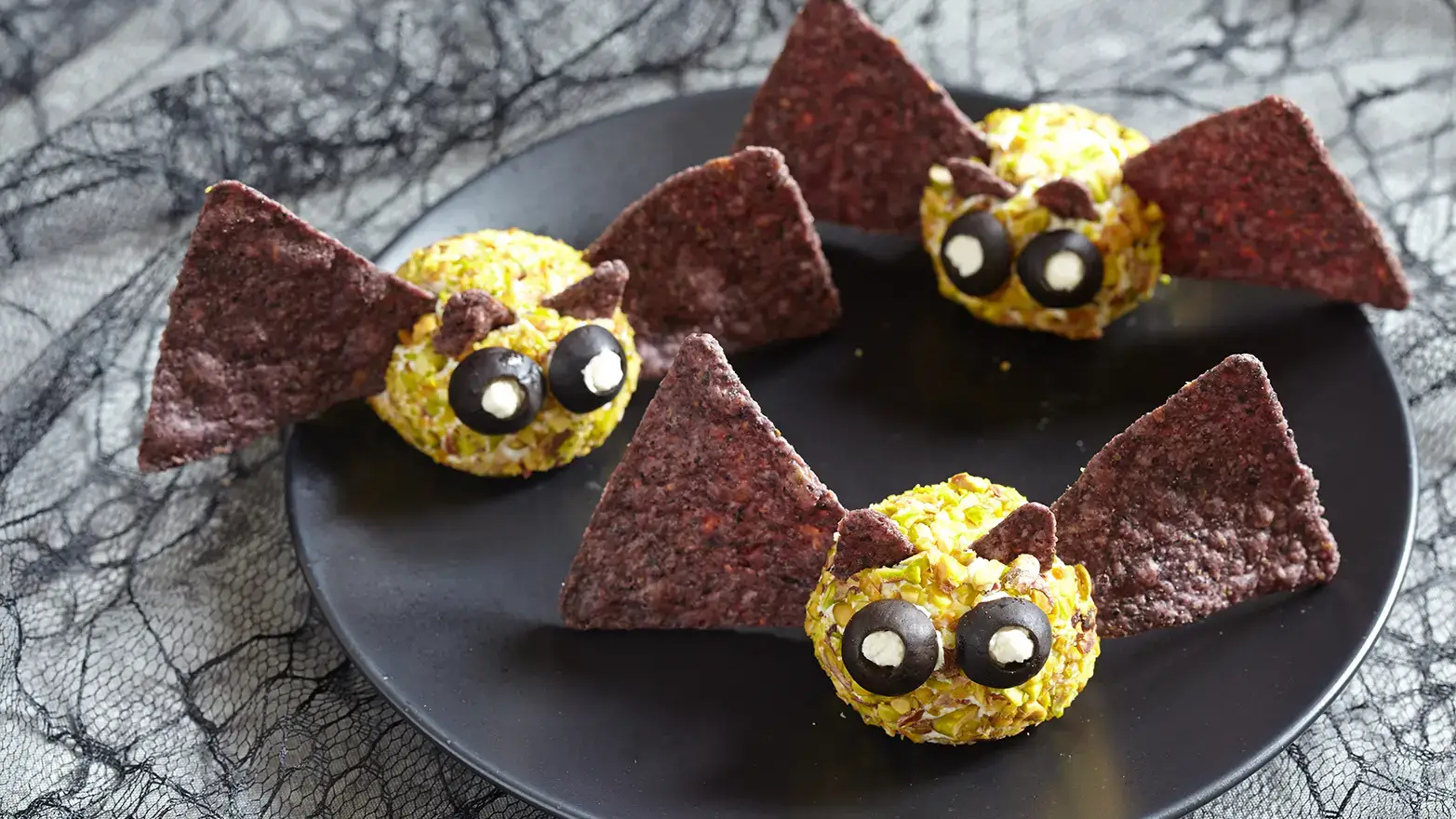 Cheese balls with tortilla ship wings and olive eyeballs