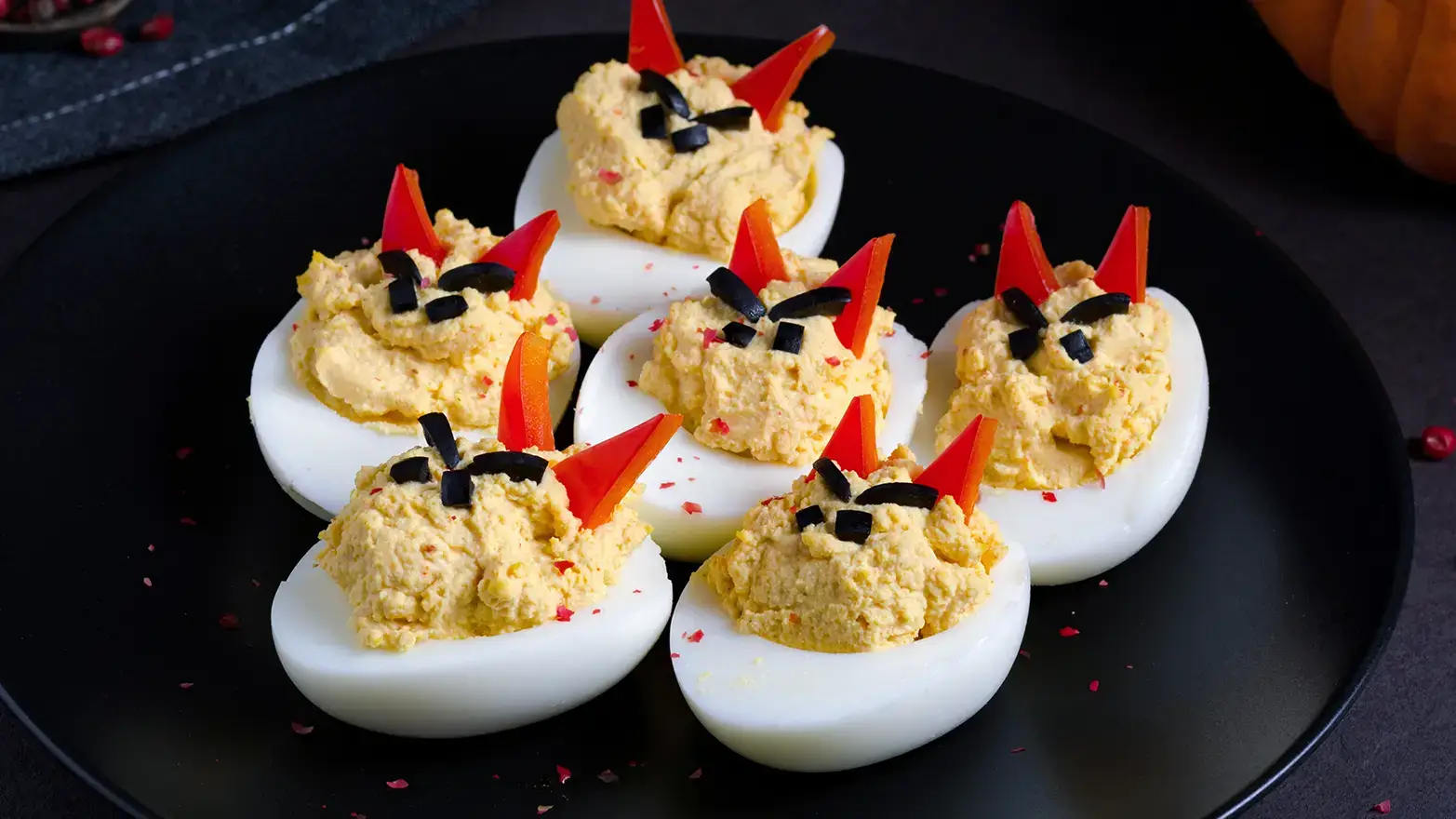 Deviled eggs with angry faces and bell pepper devil horns