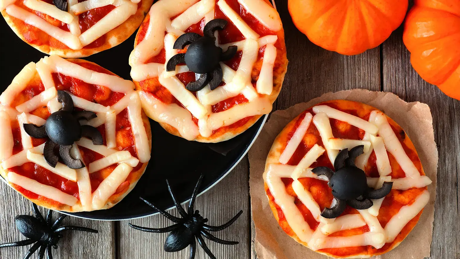 Mini pizzas with cheese spider webs and olive spiders
