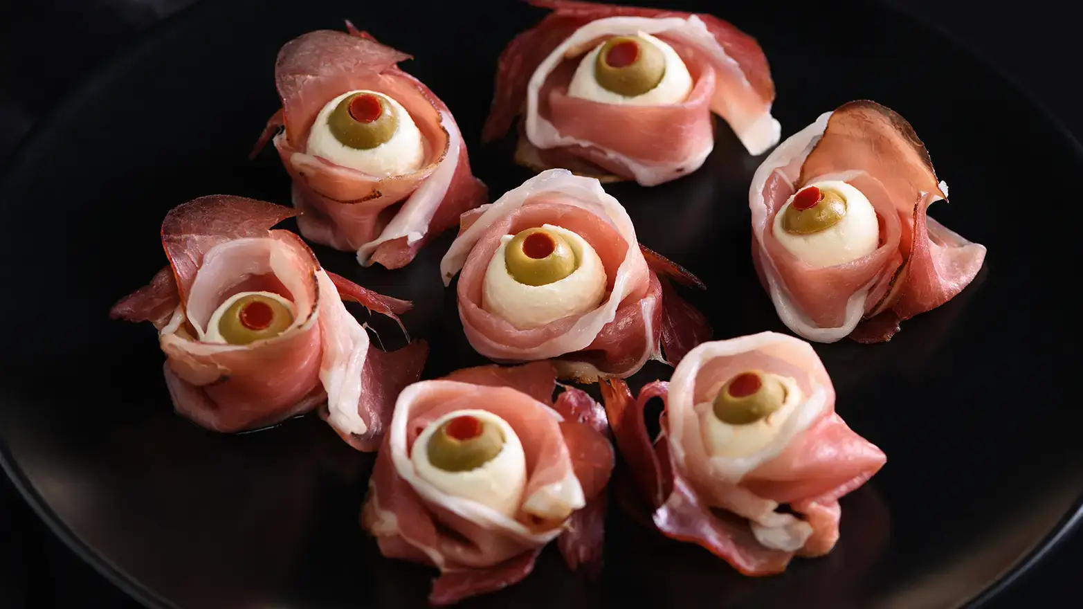 Halloween potluck dish with prosciutto wrapped eyeballs