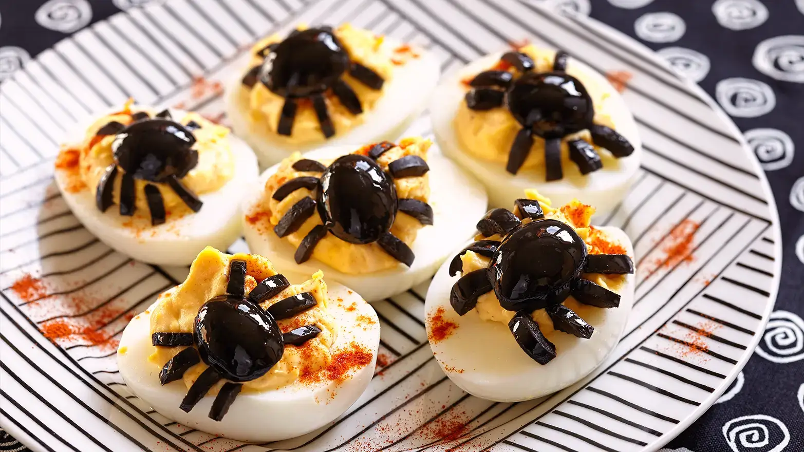 Deviled eggs topped with olive spiders