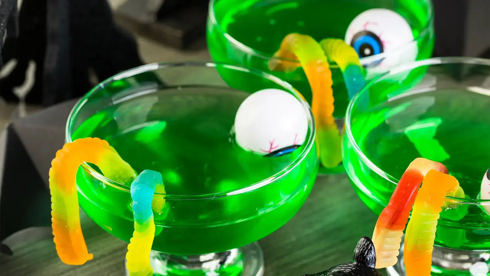 Green cocktail with gummy worms and floating eyeballs