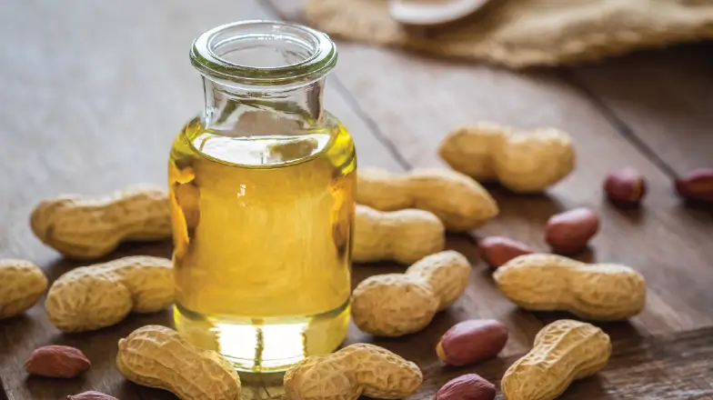 peanut oil next to a batch of peanuts