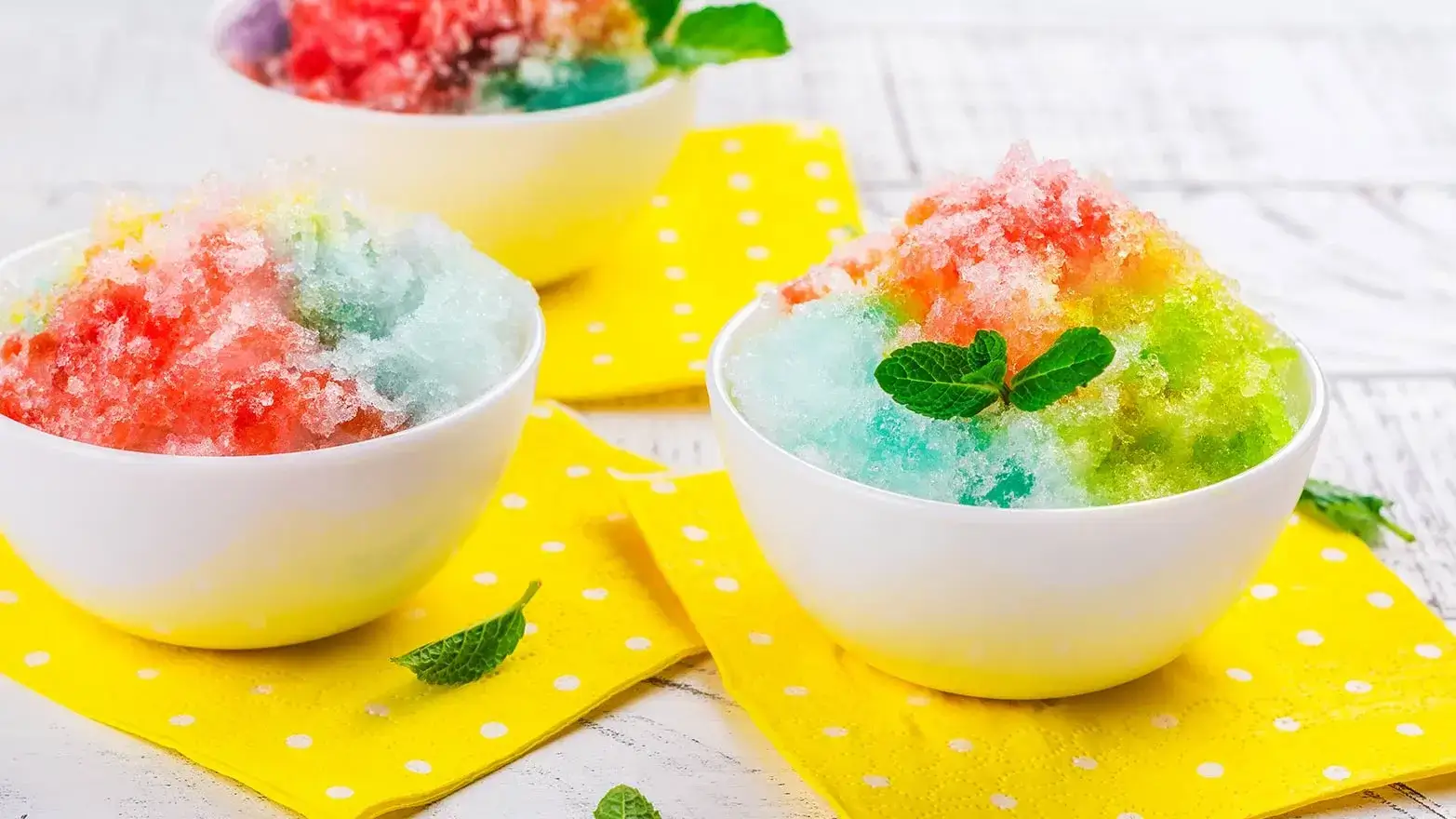 Rainbow shaved ice in a white bowl, which makes for a good ice cream alternative